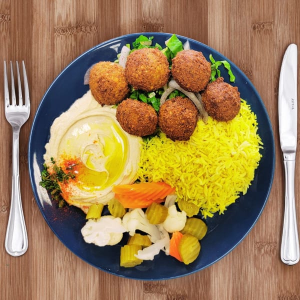 ZamZamz Mediterranean Grill falafel plate with hummus, yellow rice, salad, and pickled vegetables.